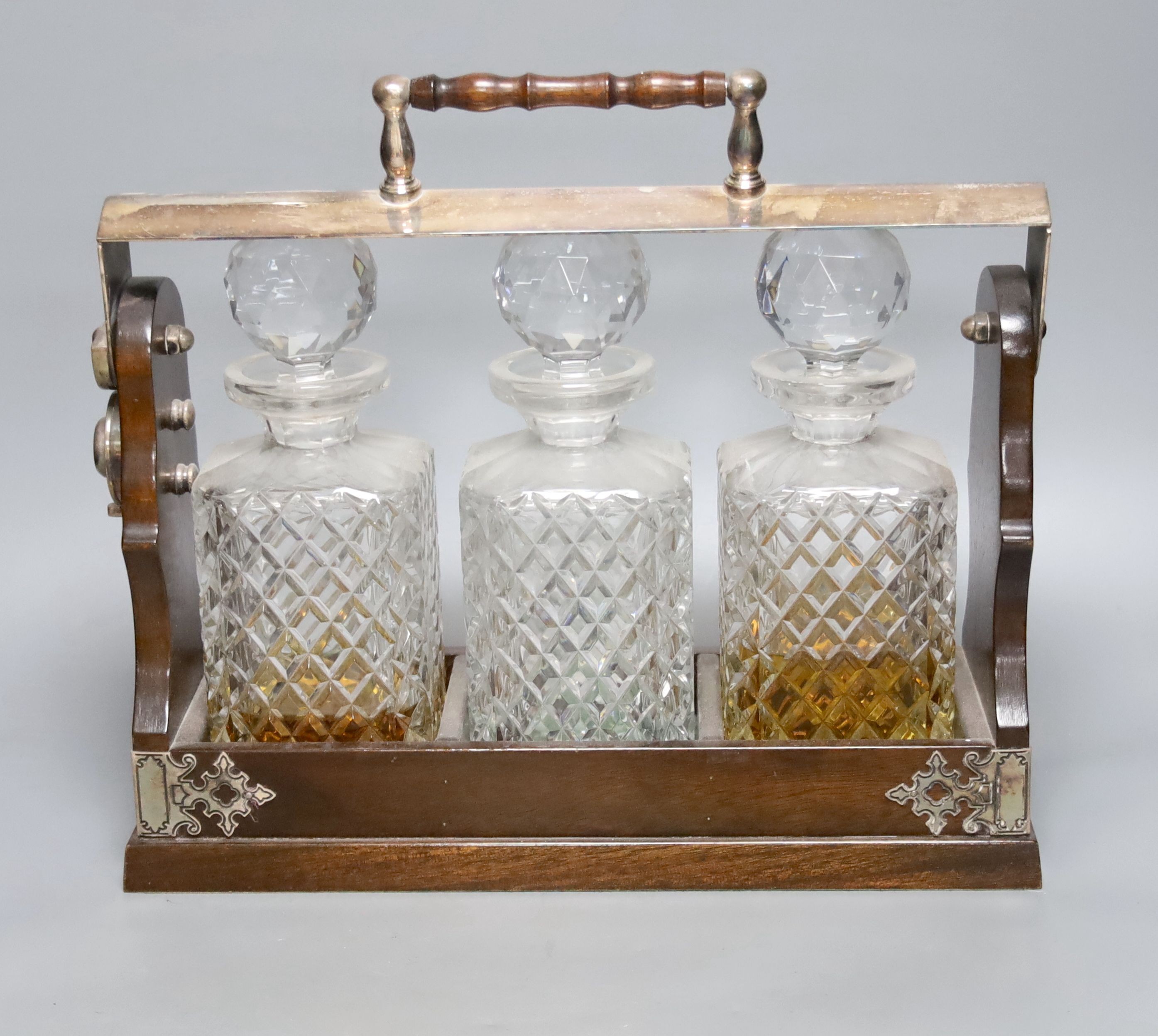 A modern silver plated three decanter tantalus, width 35cm height 32cm